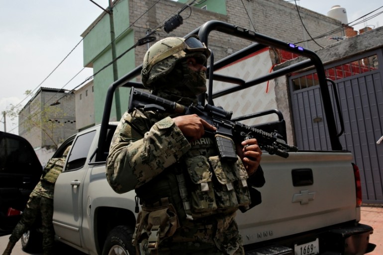 Mexican marine soldiers stand guard outside a house after suspected gang members were killed on Thursday in a gun battle with Mexican marines in Mexico City