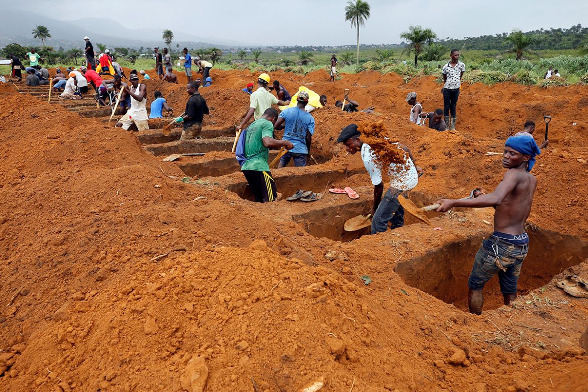 Workers are seen digging graves at Paloko cemetery in Waterloo, Sierra Leone. [Afolabi Sotunde/Reuters]