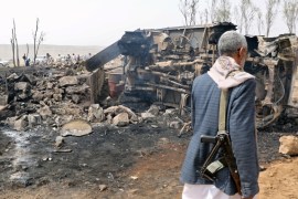A man walks at the site of a Saudi-led air strike on an outskirt of the northwestern city of Saada