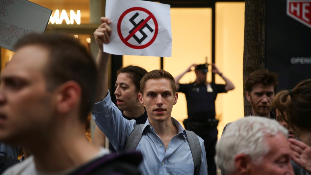 An activist holds a sign during a protest against Trump outside of Trump Tower in Manhattan, New York, US [Amr Alfiky/Reuters]