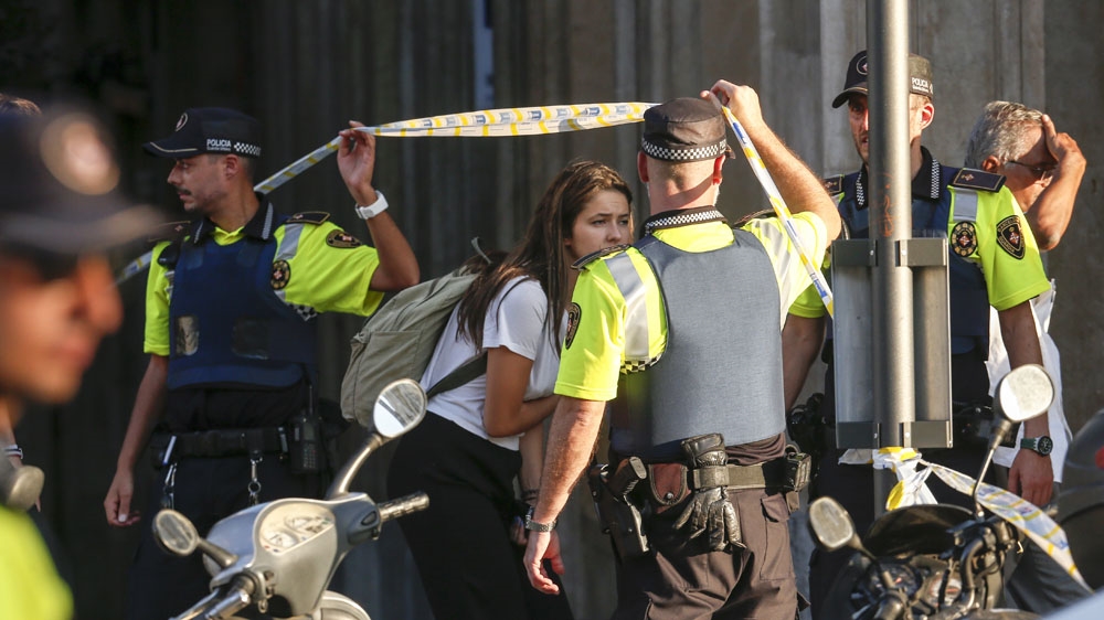 A girl leaves a cordoned off area after the van ploughed into the crowd [Lluis Gene/AFP]