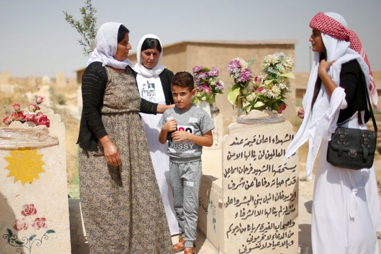 Yazidis visit a cemetery during a commemoration of the third anniversary of the Yazidi genocide in Sinjar region