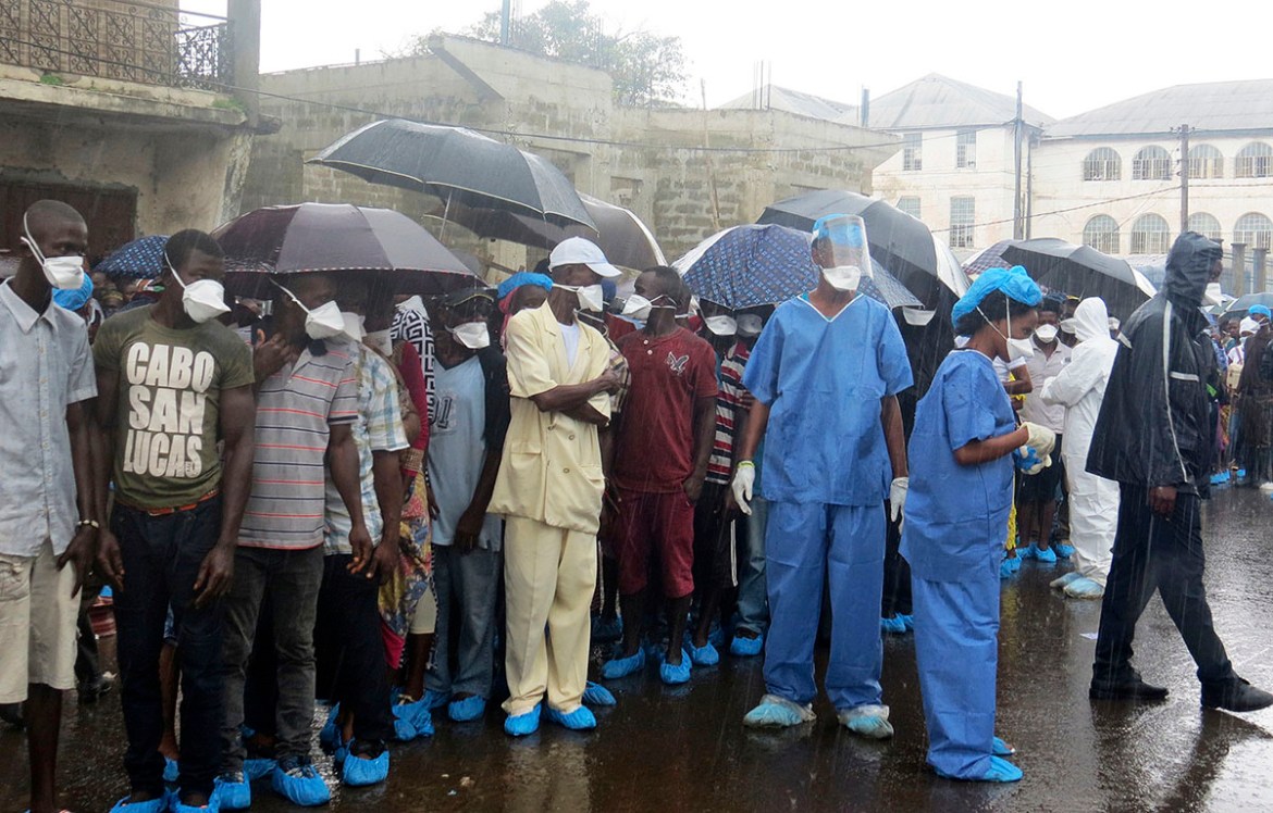 Family of victims of heavy flooding and mudslides in Regent wait to identify their bodies at Connaught hospital morgue in Sierra Leone, Freetown, Wednesday, Aug. 16 , 2017. Family members line up in