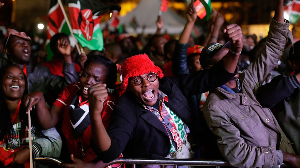 Supporters of Kenyatta cheer as they hear the election results in downtown Nairobi [AP]