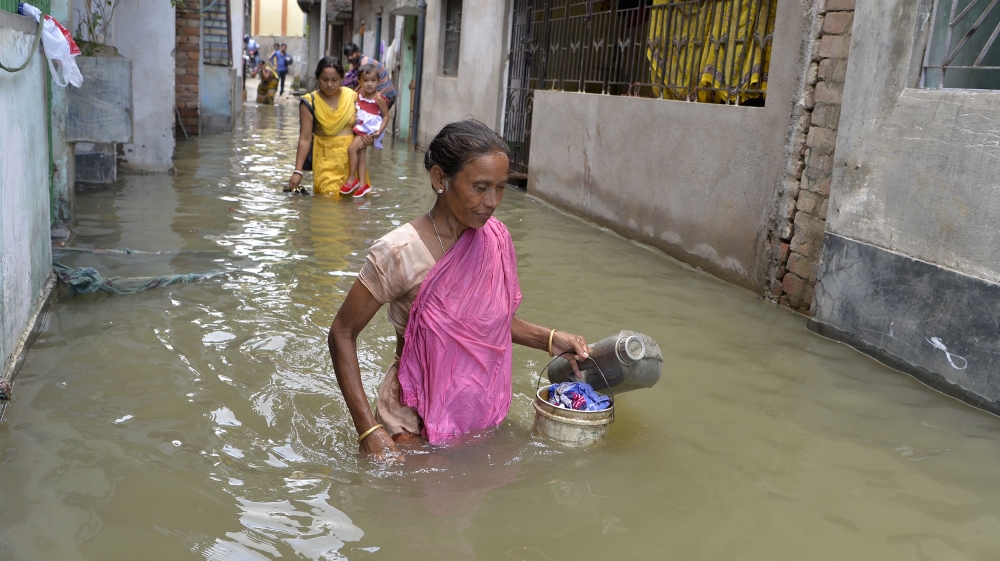 Residents walk through flood waters in Malda in the Indian state of West Bengal [Diptendu Dutta/AFP]