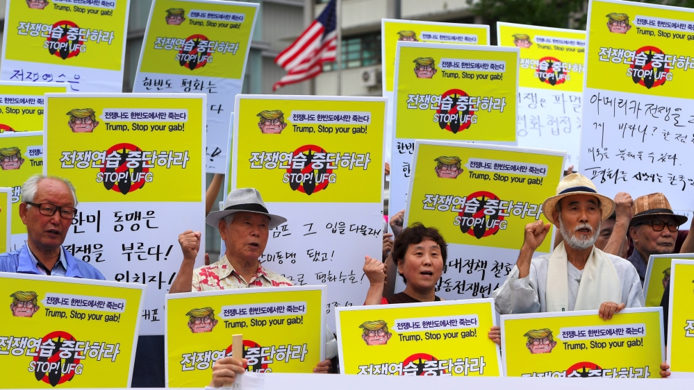 South Korean protesters hold placards that read 'stop war exercise' during a rally denouncing the military exercise [Jung Yeon-Je/AFP]