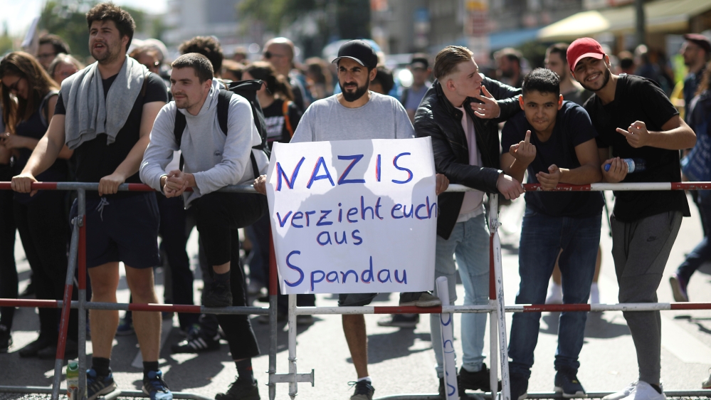 Counterprotesters raise a poster reading, 'Nazis, leave Spandau' [Christian Mang/Reuters]