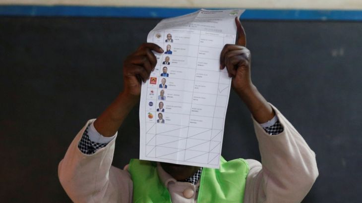 An IEBC official holds a presidential candidates ballot marked for President Uhuru Kenyatta after the close of the polling station during the presidential election in Nairobi