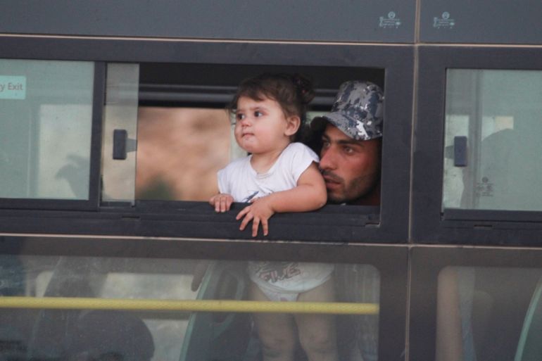 A Syrian man with a child is seen in a bus in Jroud Arsal