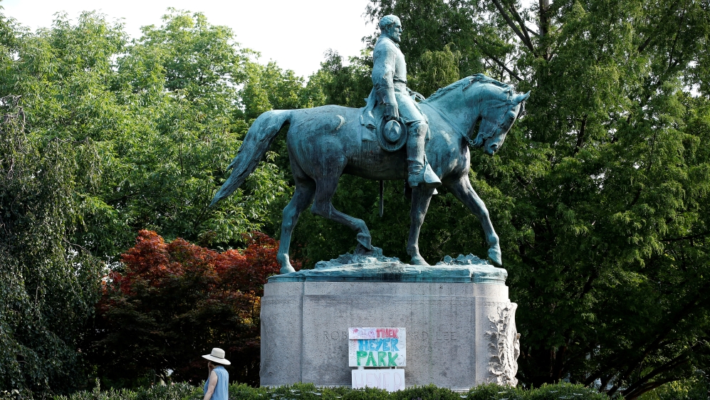 A sign on the statue of Robert E Lee calls for the park to be renamed for Heather Heyer, who was killed at a far-right rally in Charlottesville, Virginia, in August 2017 [Reuters]