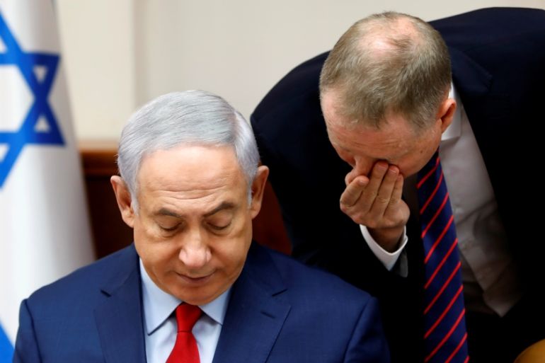 Israeli Prime Minister Benjamin Netanyahu listens to an advisor at the start of the weekly cabinet meeting at his office in Jerusalem