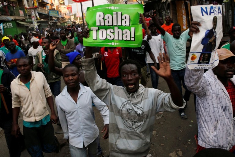 Supporters of Kenyan opposition leader Raila Odinga carry banners as they walk along a street in Humura neighbourhood