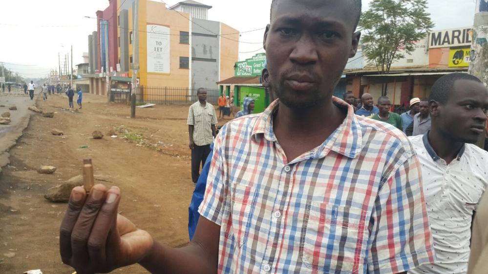 Zaphania Onyango holds up a bullet shell he says was fired by security forces [Hamza Mohamed/Al Jazeera]