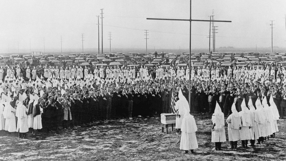 In this February 13, 1925 file photo, Ku Klux Klan members hold a ceremonial meeting near Los Angeles. Congress effectively outlawed the Klan in 1871, but it was resurrected in World War I. It grew as waves of immigrants arrived aboard ships from Europe and elsewhere, and grew more as the NAACP challenged Jim Crow laws in the South in the 1920s [AP]