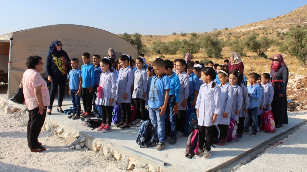 Students line up to sing the Palestinian national anthem before beginning classes [Nigel Wilson/Al Jazeera]