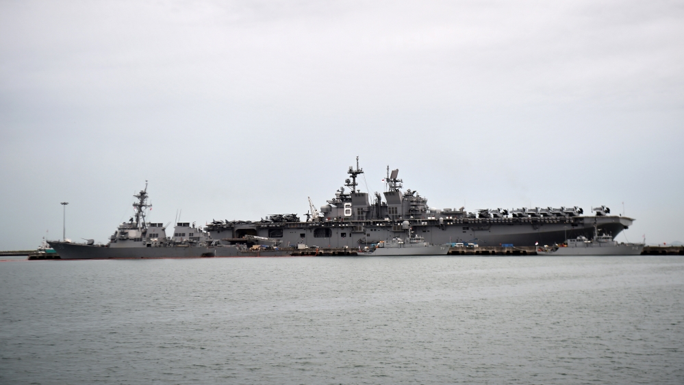 The USS John S. McCain (left), seen with a hole on its portside after the collision [Roslan Rahman/AFP/Getty Images)