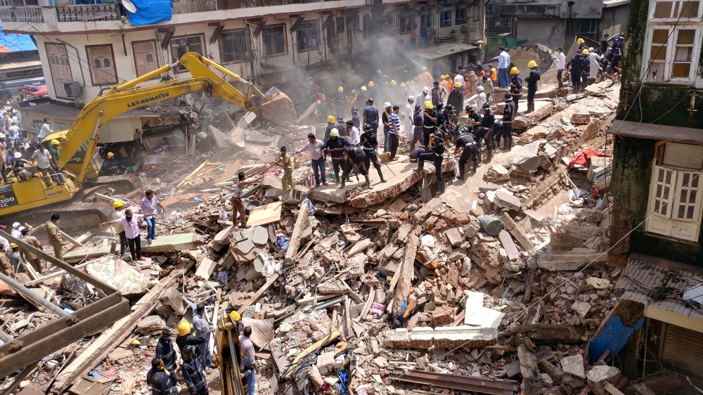 At least 11 people were killed in the building collapse, and many remain missing [Shailesh Andrade/Reuters]