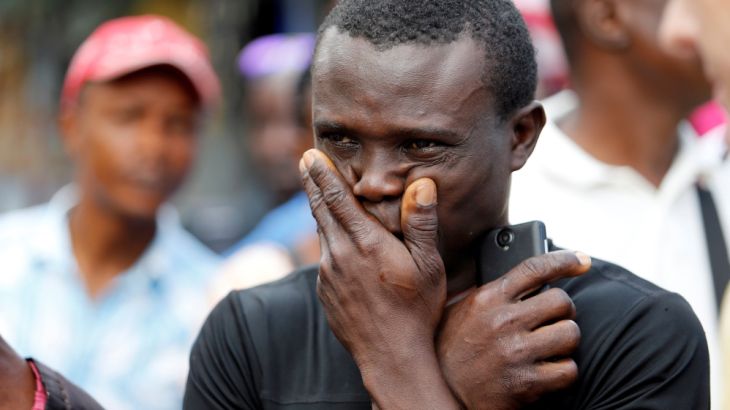 A man reacts outside the entrance of Connaught Hospital in Freetown