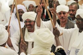 Former Sudanese President Omar al-Bashir, left, celebrates with tribal leader and father of the bride Musa Hilal after the wedding ceremony of Amani Musa Hilal and Chad President Idriss Deby Itno in Khartoum, Sudan on January 20, 2012 [File: Mohamed Nureldin Abdallah/Reuters]