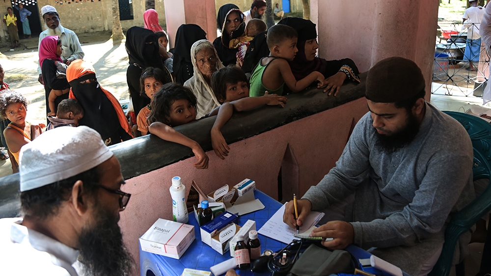 Dr Mohammad Hossain treats patients in a temporary medical camp [Showkat Shafi/Al Jazeera]