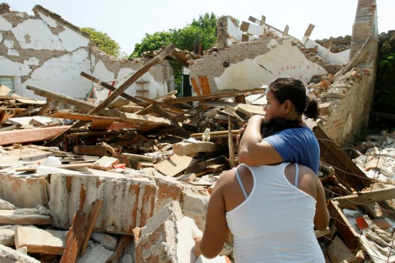 Women hug while standing next to a destroyed house after an earthquake struck the southern coast of Mexico late on Thursday, in Union Hidalgo