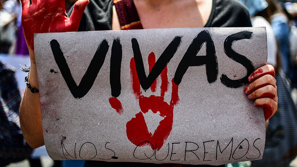 A woman holds a sign reading 'We want us alive' during the march in Mexico City [Ronaldo Schemidt/AFP]