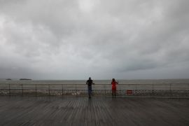 People look out at the ocean as Hurricane Maria approaches