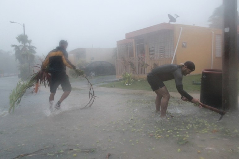 People pick up debris as Hurricane Irma howled past Puerto Rico after thrashing several smaller Caribbean islands, in Fajardo