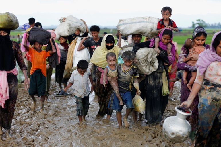 A group of Rohingya refugees walk on the muddy road after travelling over the Bangladesh-Myanmar borde