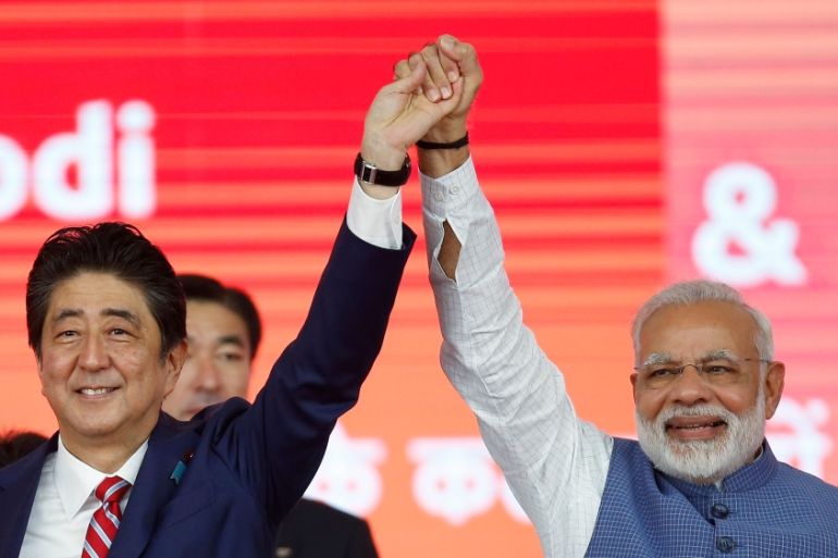 Japanese PM Abe and his Indian counterpart Modi raise hands after the groundbreaking ceremony for a high-speed rail project in Ahmedabad