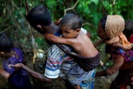 Rohingya refugees climb up a hill after crossing the Bangladesh-Myanmar border in Cox''s Bazar