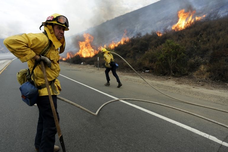 Firefighters monitor the LaTuna fire burning alongside the 210 freeway in Sunland, California, USA, 02 September 2017