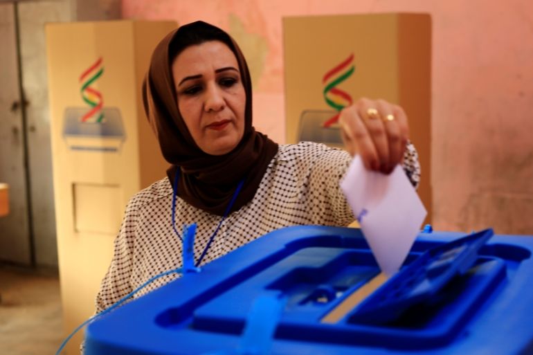 An employee casts her vote at a polling station for Kurds independence referendum in Kirkuk