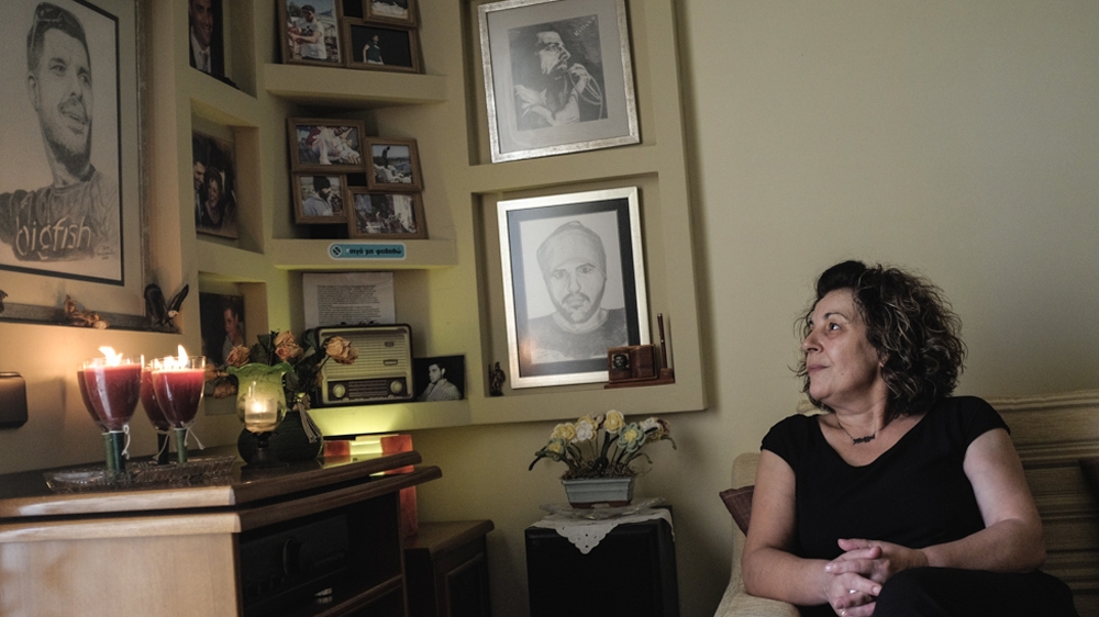 Magda Fyssas sits in her living room gazing at a corner dedicated to her late son in September 2017 [Nick Paleologos/SOOC/Al Jazeera]