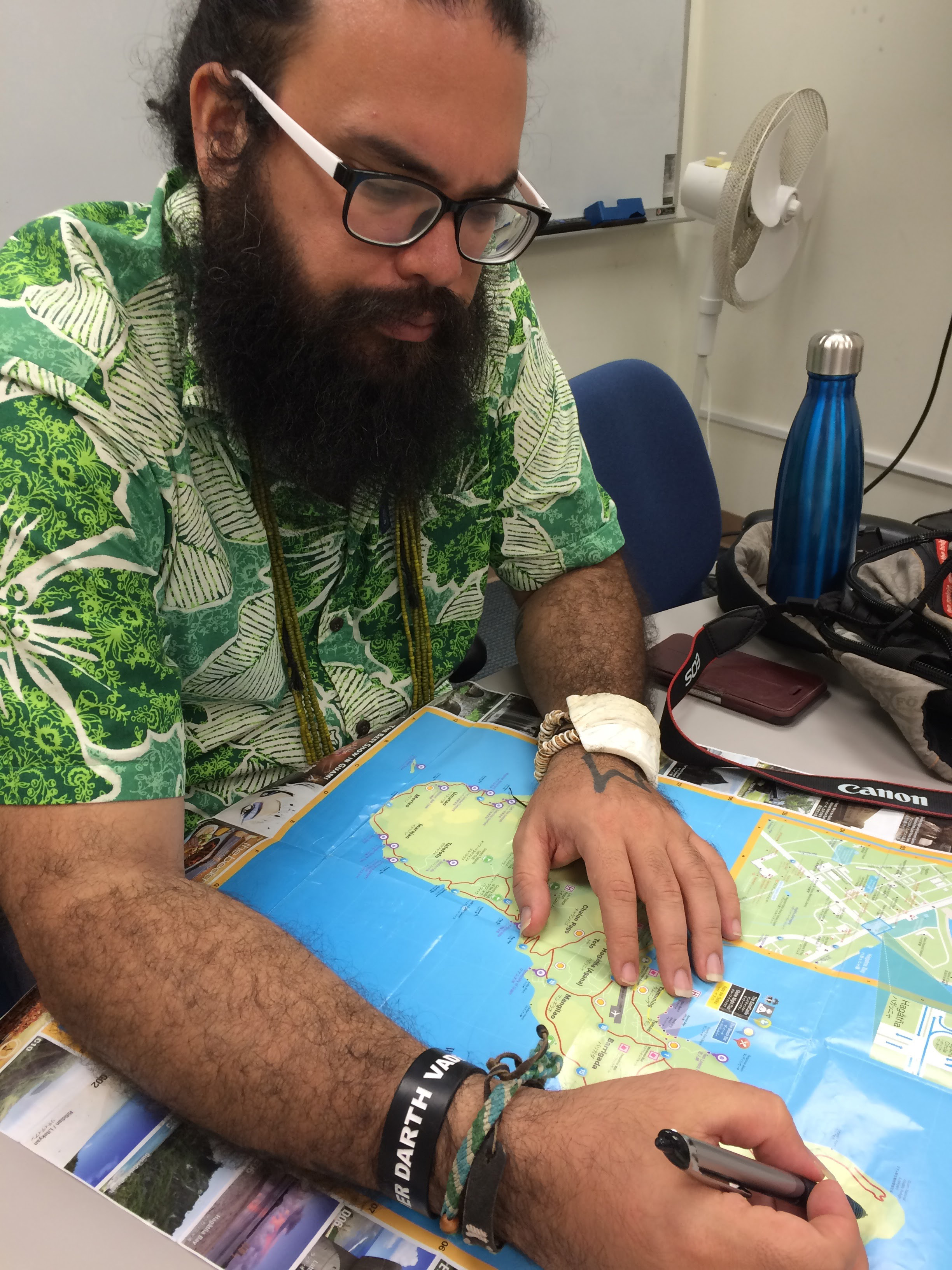 Michael Lujan Bevacqua uses a map to show where US bases on Guam are located. The military occupies nearly one-third of the island [Jon Letman]