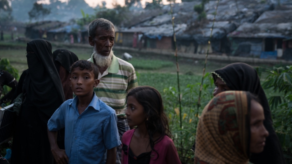 Recently-arrived Rohingya refugees wait for donations outside Kutupalong shelter camp [Katie Arnold/Al Jazeera]