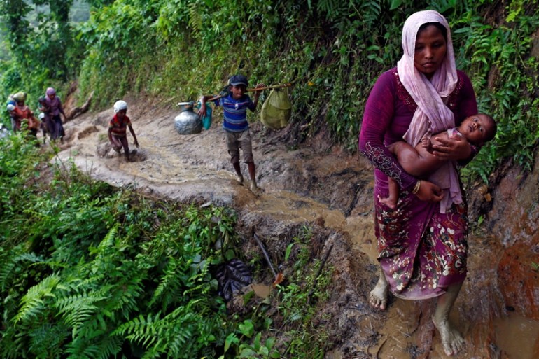 Rohingya refugees climb up a hill after crossing the Bangladesh-Myanmar border