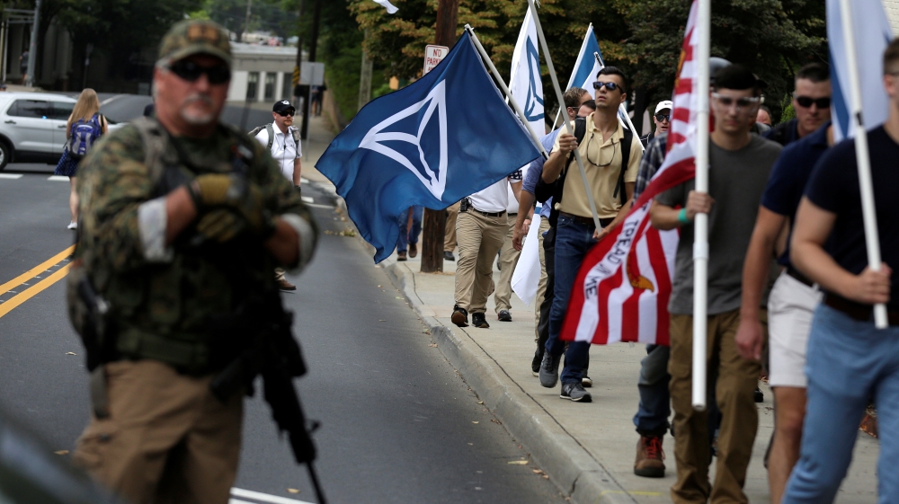 White nationalists pass a militia member during the August 2017 Charlottesville rally [File: Joshua Roberts/Reuters]