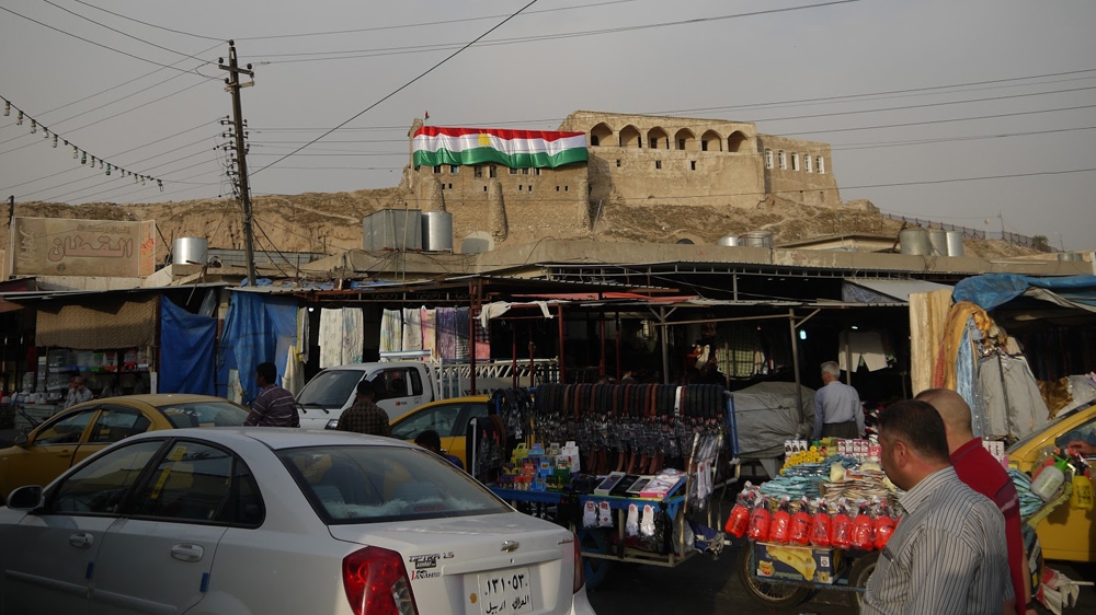 A Kurdish flag hangs atop the city's ancient citadel [Sofia Barbarani/Al Jazeera] 