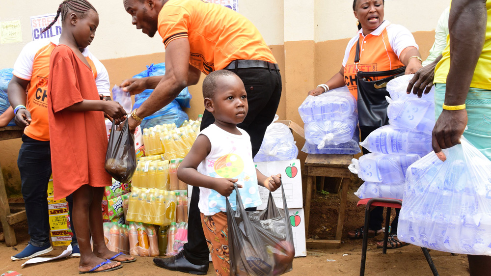 A child receives a bag of supplies from disaster relief volunteers on August 18, 2017, in Freetown, following heavy rains which resulted in more than 1000 deaths [SEYLLOU/AFP/Getty Images]