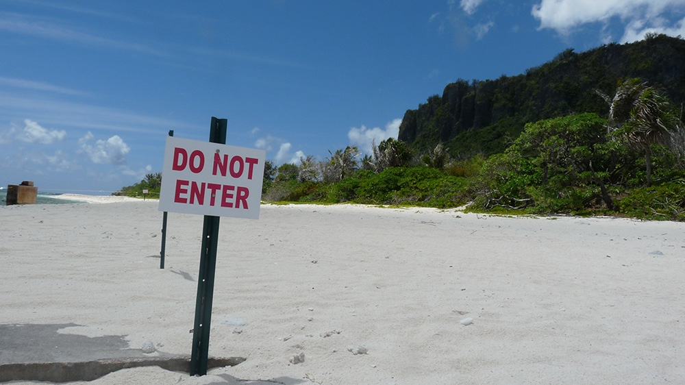 Beyond this sign sits Anderson Air Force Base on Guam's northernmost point Litekyan (Ritidian). The US military plans to build a live-fire traning range complex in the area on land many indigenous Chamorro people consider sacred [Jon Letman/Al Jazeera]