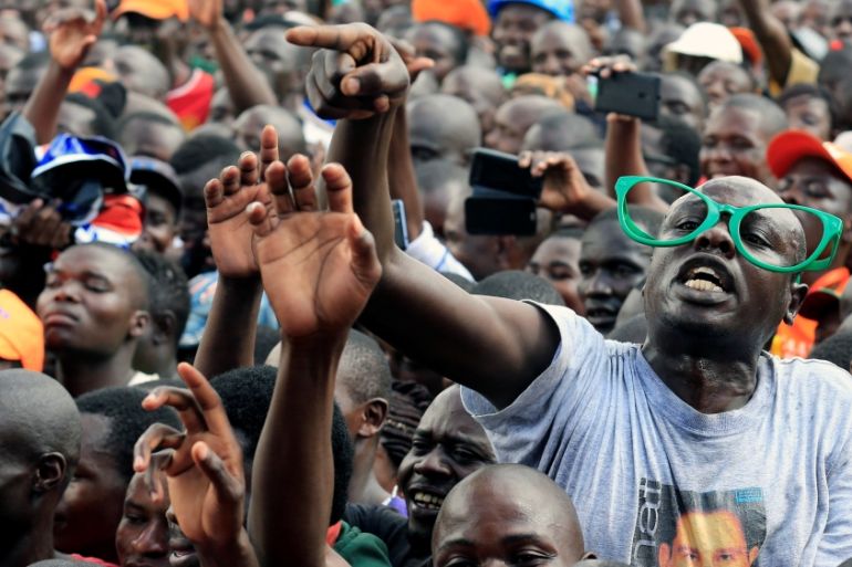 Supporters of Kenyan opposition leader Raila Odinga, the presidential candidate of the National Super Alliance coalition cheers his speech during a rally at the Jacaranda grounds in Nairobi
