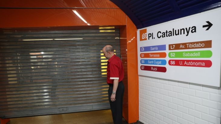 A worker closes an entrance gate to Catalunya Square subway station during a partial regional strike called by pro-independence parties and unions in Barcelona