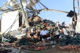 People move the remaining pomegranate fruits after a Saudi-led air raid in Saada, Yemen October 17, 2017 [Naif Rahma/Reuters]