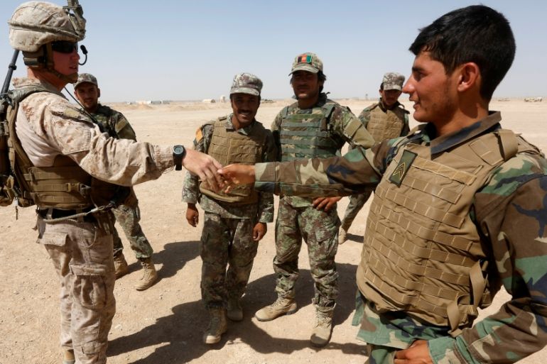 A U.S. Marine (L) shakes hand with Afghan National Army (ANA) soldiers during a training exercise in Helmand province, Afghanistan