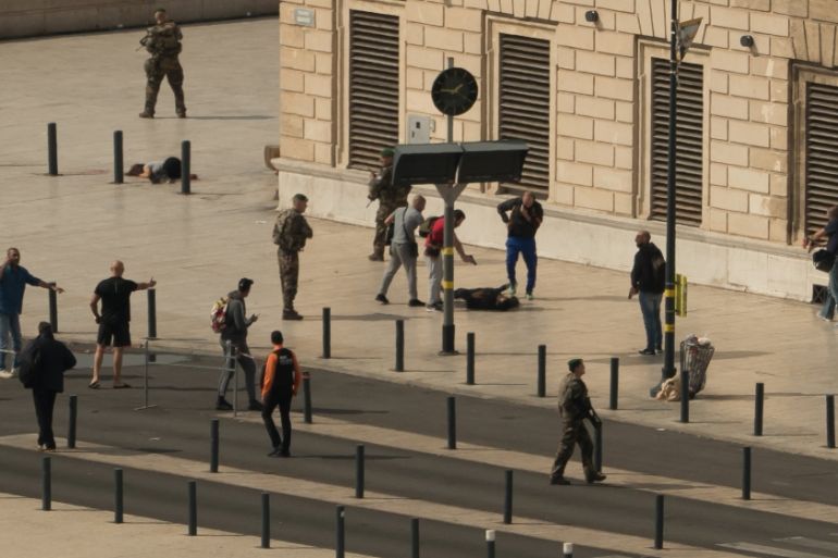 The assailant is seen on the ground surrounded by police during the attack at Saint-Charles station in Marseille