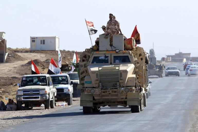 Iraqi soldiers ride in military vehicles in Zumar