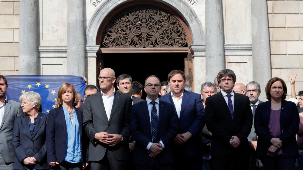 Catalan President Carles Puigdemont, second from right, and other politicians stand in front of the regional government headquarters to protest against the Catalan activists' imprisonment [Gonzalo Fuentes/Reuters]