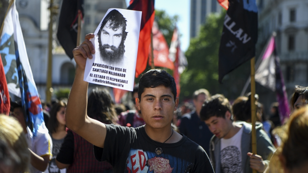A man holds a portrait of Santiago Maldonado during a protest on Thursday [Eitan Abramovic/AFP/Getty Images]