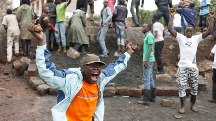 An opposition supporter gestures during clashes with police in Kibera slum in Nairobi